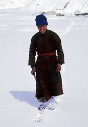 Zanskari child who has fashioned makeshift skis from pieces of hose-pipe